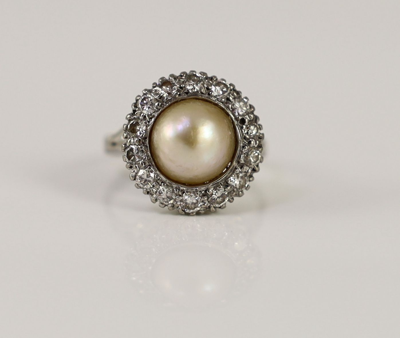 A mid 20th century platinum?, split pearl and diamond set circular cluster ring